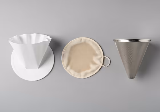 A side-by-side comparison of a reusable metal coffee filter and a disposable Chemex paper filter.