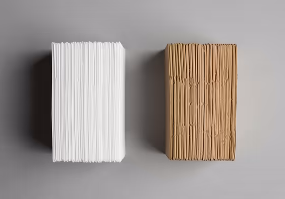 A side-by-side comparison of a stack of white Chemex filters and a stack of brown natural Chemex filters.