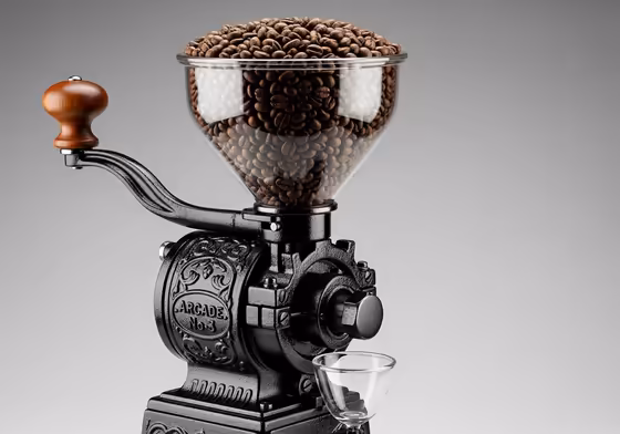 An ornate American-made Arcade Crystal No. 3 wall-mounted coffee grinder with its signature glass bean hopper.